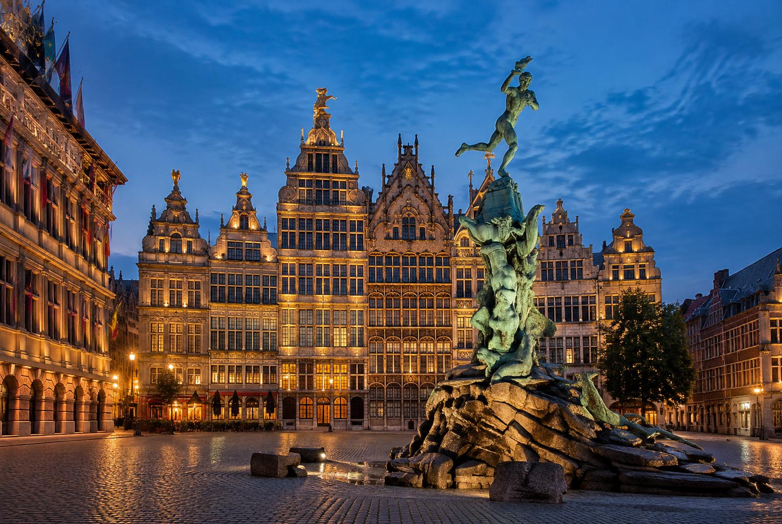 De Grote Markt van Antwerpen met de Brabofontein en verlichte gildehuizen bij avond